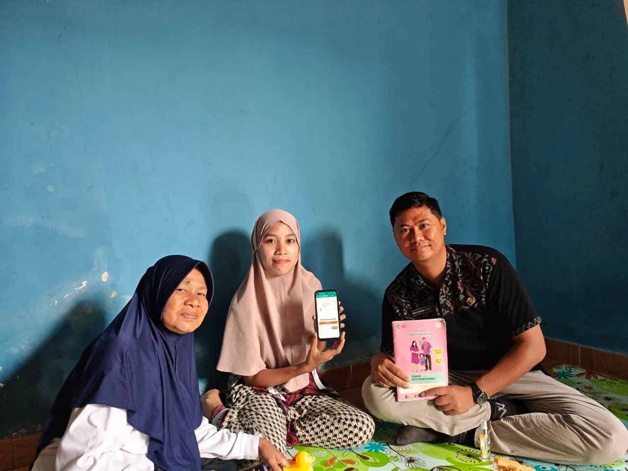 Seorang ibu menunjukkan ponsel kepada petugas